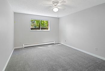 A room with a ceiling fan and a window.